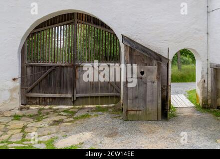 Historischer Eingang und Tor mit Holzgrube Latrine dazwischen Stockfoto