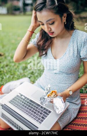 Schöne asiatische Frau, die im Park arbeitet und die schöne Aussicht und die frische Luft genießt. Stockfoto