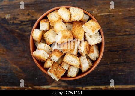 Croutons Bier Snack Cracker in einem Teller auf einem braunen Holzhintergrund. Blick von oben Stockfoto