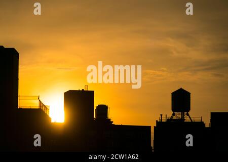 Die Sonne untergeht unter den East Village Gebäuden in New York City. Stockfoto