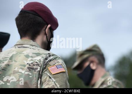 Amerikanische Flagge auf Soldatenarm und US-Soldaten tragen schützende Gesichtsmasken. Quarantäne in der Armee. Militärische Streitkräfte der Vereinigten Staaten von Amerika. Stockfoto