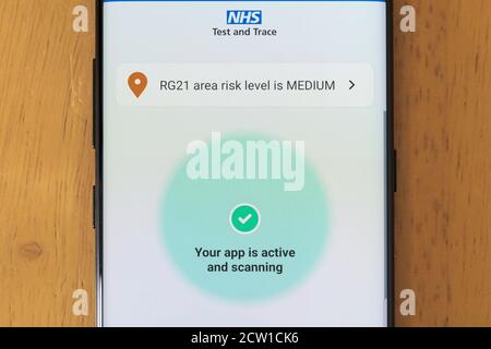 Die NHS Test und Trace App auf einem Smartphone-Bildschirm aktiv und Scannen zeigt das Risiko für ein Gebiet in England, Großbritannien Stockfoto