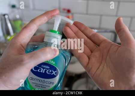 Ein Mann, der antibakterielle Händedesinfektionsmittel verwendet, um Flüssigseife in seine Hände zu geben. Konzept Sauberkeit, Händewaschen, Covid-19, Coronavirus, OCD Stockfoto