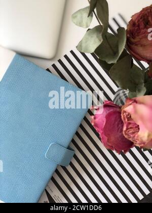 Blaues Notizbuch mit Kaffee und Rosen Stockfoto