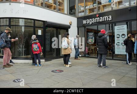 Besucher von Hampstead stehen vor dem Wagamama Restaurant mit Schildern an Beratung zur sicheren sozialen Abstand wegen Coronavirus / zu halten Covid-19 Pandemie in L Stockfoto