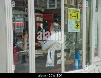 Besucher des Hampstead Cafés mit Schildern, die darauf hinweisen, dass sie sicher sein sollten Soziale Distanz durch Coronavirus / Covid-19 Pandemie in London, England, Großbritannien Stockfoto