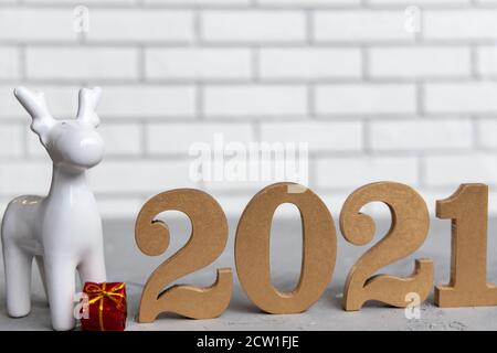 Neujahr roter Hintergrund mit glänzenden goldenen Zahlen 2021 und silbernen Kiefernzapfen. Minimalistisches Konzept auf rotem Papier mit harten Schatten. Stockfoto