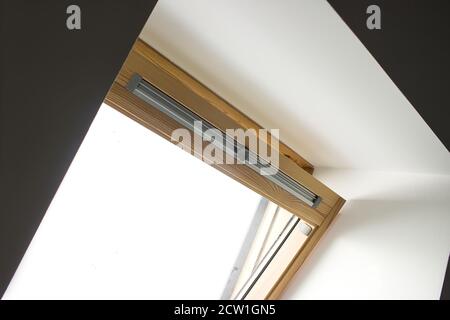 Ein modernes offenes Dachfenster in einem Dachgeschoss Gegen den Himmel Stockfoto