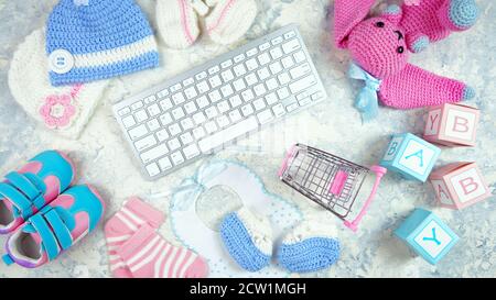 Baby-Kindergarten Kleidung Mama Blogger Desktop-Arbeitsplatz mit rosa und blauen Accessoires und Warenkorb auf weißem Marmor texturierten Hintergrund. Draufsicht BL Stockfoto