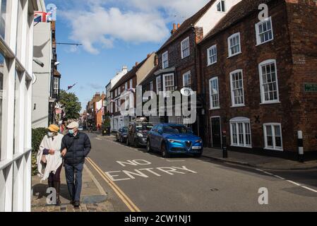 Eton, Großbritannien. September 2020. Ein Mann und eine Frau tragen Gesichtsbezüge, um die Ausbreitung des Coronavirus in der Eton High Street zu verhindern. Der Royal Borough of Windsor and Maidenhead ist sich eines Anstiegs der lokalen Coronavirus-Infektionen bewusst, hat einen COVID-19-Ausbruchsmanagementplan erstellt, um sicherzustellen, dass die Zahl nicht weiter steigt, und hat vor diesem Hintergrund den Zugang zu weiteren Coronavirus-Teststandorten beantragt. Kredit: Mark Kerrison/Alamy Live Nachrichten Stockfoto