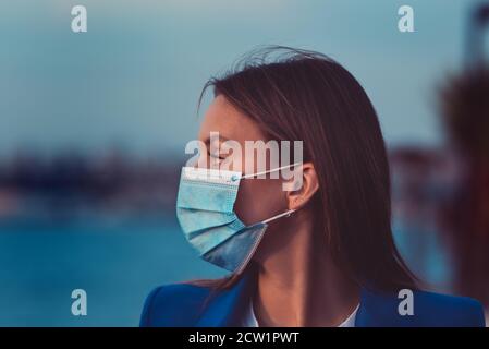 Schöne Frau in einer Einweg-medizinische Maske. Schutz vor Coronaviren Stockfoto