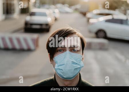 Weißer junger Mann in einer medizinischen Maske. Coronavirus-Schutz. Stockfoto