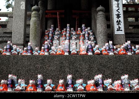 Dutzende inari/ Fuchsgötter auf einem Grab am Fushimi Inari Schrein. Kyoto, Japan Stockfoto