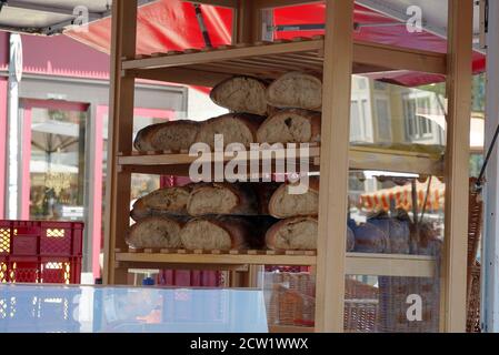 Ein Bäckermarktstand mit hausgemachten Brotsorten in den Regalen am Samstagsmarkt in Freiburg im Breisgau am Domplatz. Stockfoto