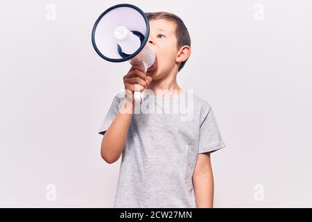 Liebenswert kaukasischen Kind Junge mit wütend Ausdruck. Schreiend laut mit Megaphon stehend über isolierten weißen Hintergrund Stockfoto