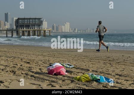 Erwachsener Mann läuft am Strand, Durban, KwaZulu-Natal, Südafrika, Aktivität am Meer, Training, Landschaft, Stadt, Wasser, Ushaka Steg, Handtücher, Reisen Stockfoto