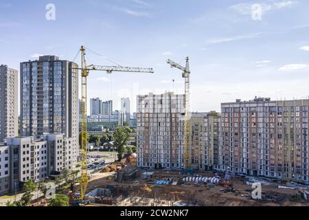 Neue Wohngebäude im Bau. Zwei Turmdrehkrane vor blauem Himmel Hintergrund Stockfoto