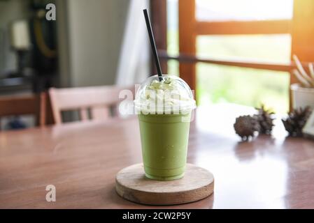 Grüner Tee Smoothie / Matcha grüner Tee mit Milch auf In einem Café wird Plastikglas serviert Stockfoto
