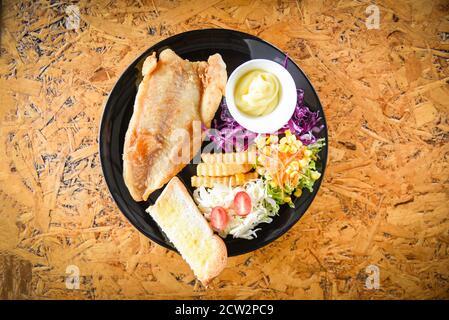 Fischgericht Steak Fisch mit Sauce Sahne französisch frites Brot Und frisches Gemüse auf Teller / gebratenes Fischfilet Stockfoto