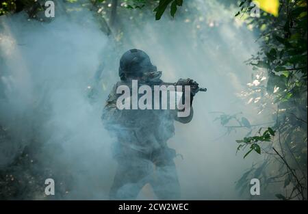 Voll ausgestattete Soldaten tragen Camouflage Uniform angreifenden Feind, Airsoft militärischen Spielspieler in Camouflage Uniform Stockfoto