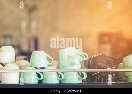 Gruppe von Kaffeetassen in der Café-Bar, grün braun und weiß Kaffeetasse Glas auf dem Regal im Geschäft, viele leere Tassen Stockfoto