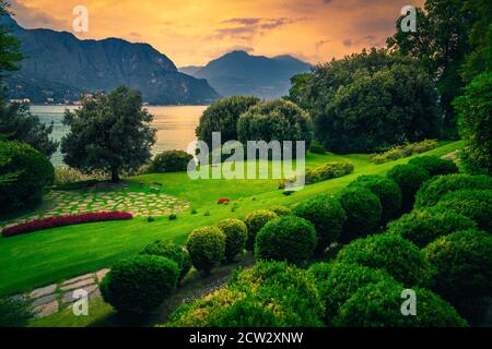Gehweg und Ruheplatz im wunderschönen Ziergarten bei Sonnenuntergang, Comer See, Lombardei, Italien, Europa Stockfoto