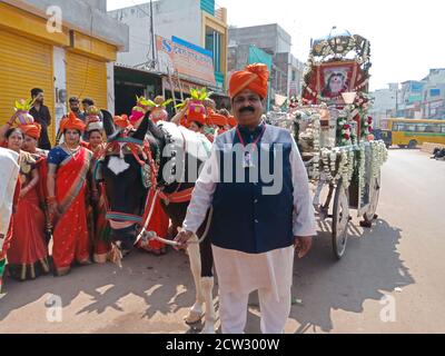 DISTRIKT KATNI, INDIEN - 09. FEBRUAR 2020: Traditioneller asiatischer Mann hält Pferd Zaum für religiöse Kundgebung auf der Straße nach jagannath Rath yatra. Stockfoto