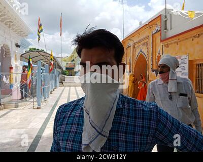 DISTRIKT KATNI, INDIEN - 08. JULI 2020: Traditioneller indischer Junge, der Facemask für Coronavirus-Schutz am hinduistischen religiösen Ort trägt, während der Reise. Stockfoto