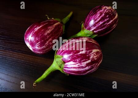 Eine Nahaufnahme von frischen, auf einem texturierten Tisch isolierten Brinjalen In der Küche Stockfoto