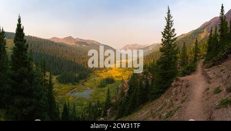 Panoramablick auf ein bergiges Tal entlang der Four Pass Loop in Colorado bei einem trüben Sonnenaufgang am Morgen. Stockfoto