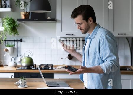 Frustrierter Mann verwirrt durch finanzielle Fehler bei der Zahlung Stockfoto