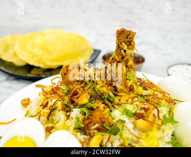 Nahaufnahme einer Hühnchen-Biryani-Platte auf weißem Marmorboden Stockfoto