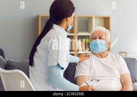 Fürsorglicher unterstützender Arzt, der ältere männliche Patienten zu Hause während besucht Coronavirus-Pandemie Stockfoto