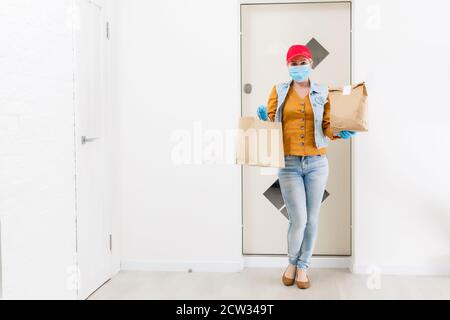 Maskierte Geburt Frau liefert Nahrung während Virusausbruch, Coronavirus Panik und Pandemien. Stockfoto