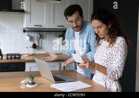 Unglückliches Paar frustriert durch Schuldzahlungen Rechnungen online Stockfoto