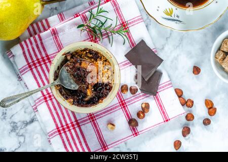 Birnenbrösel Dessert mit Schokolade und Haselnüssen Stockfoto