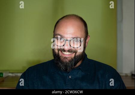 Der Mensch lacht diebisch und schelmisch an der Kamera Stockfoto