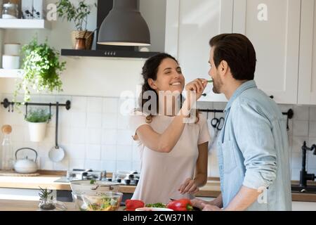 Lächelndes Paar haben Spaß beim Kochen in der heimischen Küche Stockfoto