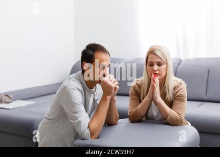 Junge Familie zu Hause beten Stockfoto