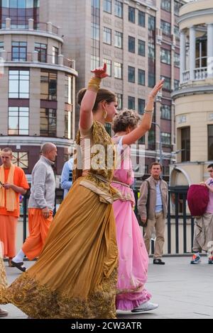 Hare Krishna Anhänger. Hare Krishna Mädchen in schönen Saree Kleider tanzen auf der Straße Stockfoto