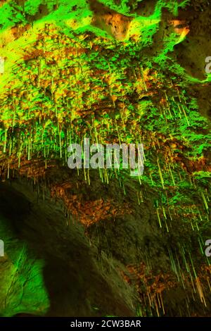 Magisches Innere der alten Kalksteinhöhle, fantastische grüne Stalagmite glüht in Lichtern. Khao Bin Cave, Ratchaburi, Thailand. Low-Angle-Ansicht. Stockfoto