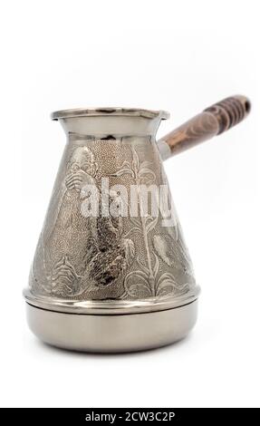 Kupfer-Türke oder Cezve mit einem Holzgriff zum Brühen von Kaffee isoliert auf einem weißen Hintergrund. Stockfoto