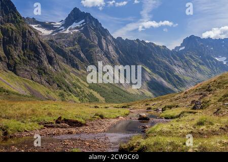 ROMEDALEN, NORWEGEN - 2014. JULI 21. Verträumtes Bergtal mit grünen Wäldern, Felsen und Fluss. Stockfoto