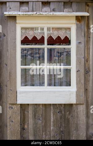 ROMEDALEN, NORWEGEN - 2014. JULI 21. Weiß gerahmtes Fenster auf einem alten Bauernhaus in den Bergen von Norwegen. Stockfoto