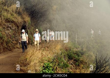 Madeira, Portugal - September 2017: Eine Gruppe von Wanderern, die aus dem Nebel auf einer Bergstrecke aufsteigen Stockfoto