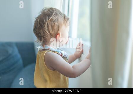 Baby schaut durch das Fenster Stockfoto