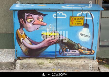 Graffiti lustige Straßenkunst buntes Gemälde, das Jungen mit Geburtstagskuchen auf Powerbox in Sofia, Bulgarien, Osteuropa, Balkan, EU darstellt Stockfoto