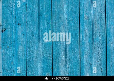 Alte Holzbretter mit zerbröckelter, rissiger blauer Farbe in der Nähe Blauer Hintergrund Stockfoto