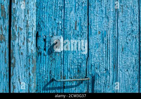 Alte Holzbretter mit zerbröckelter, rissiger blauer Farbe in der Nähe Blauer Hintergrund Stockfoto