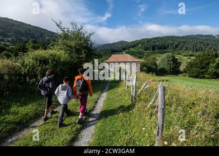 Escursionistas frente a la ermita de Arrako, valle de Belagua, Isaba, Navarra, Spanien, Europa Stockfoto